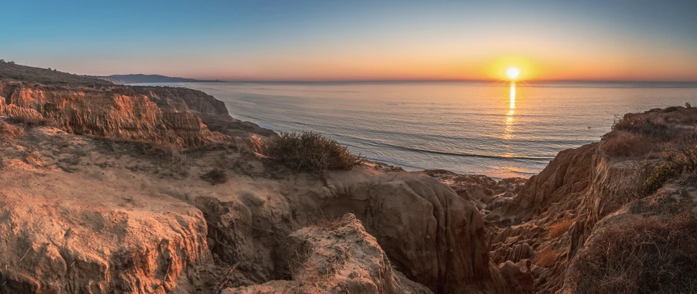 Breathtaking view looking down the rugged sandstone cliffs of Razor Point at sunset, Torrey Pines States National Reserve.