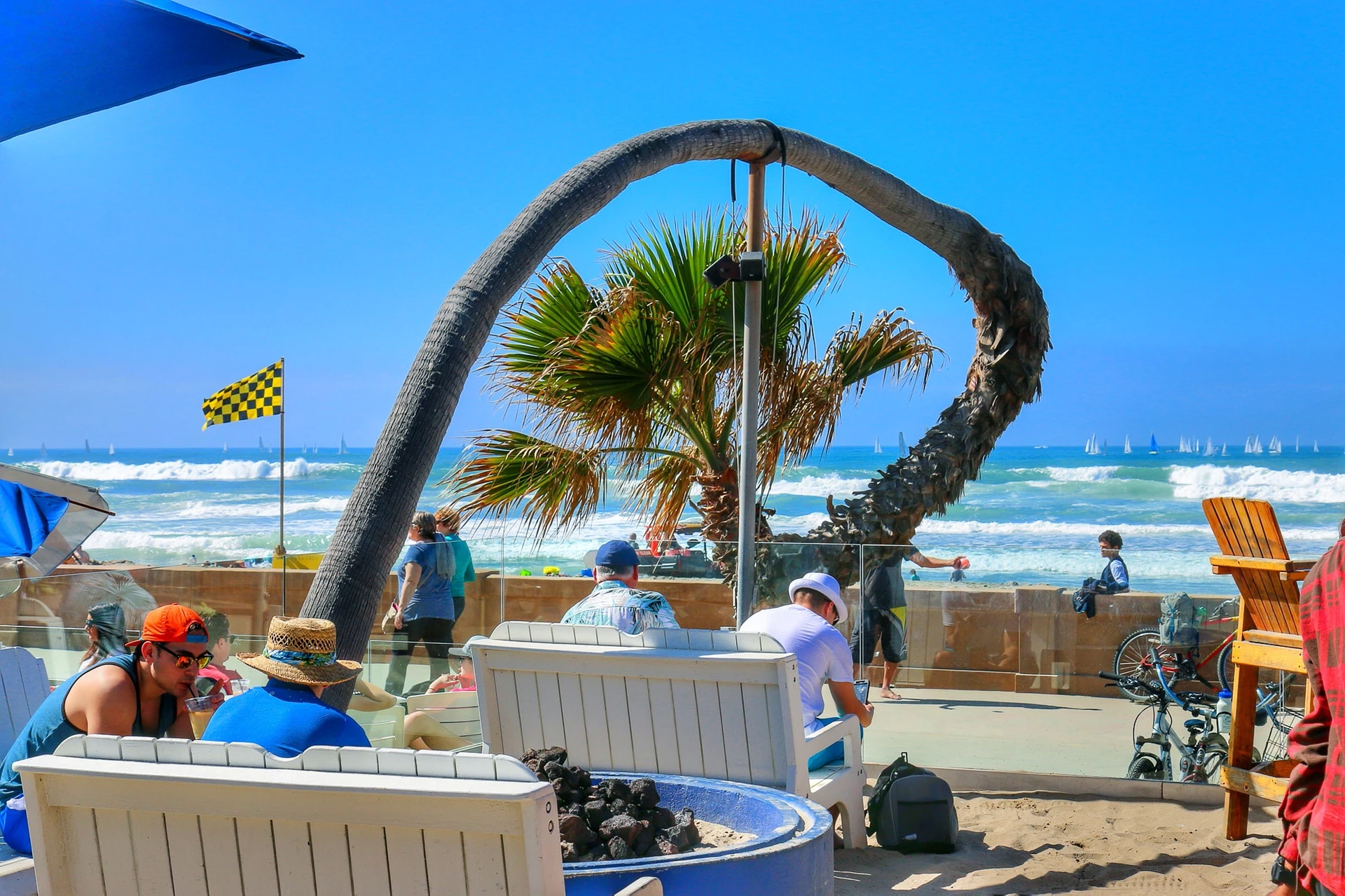 People sit at Belmont Park near the beach in San Diego in June.