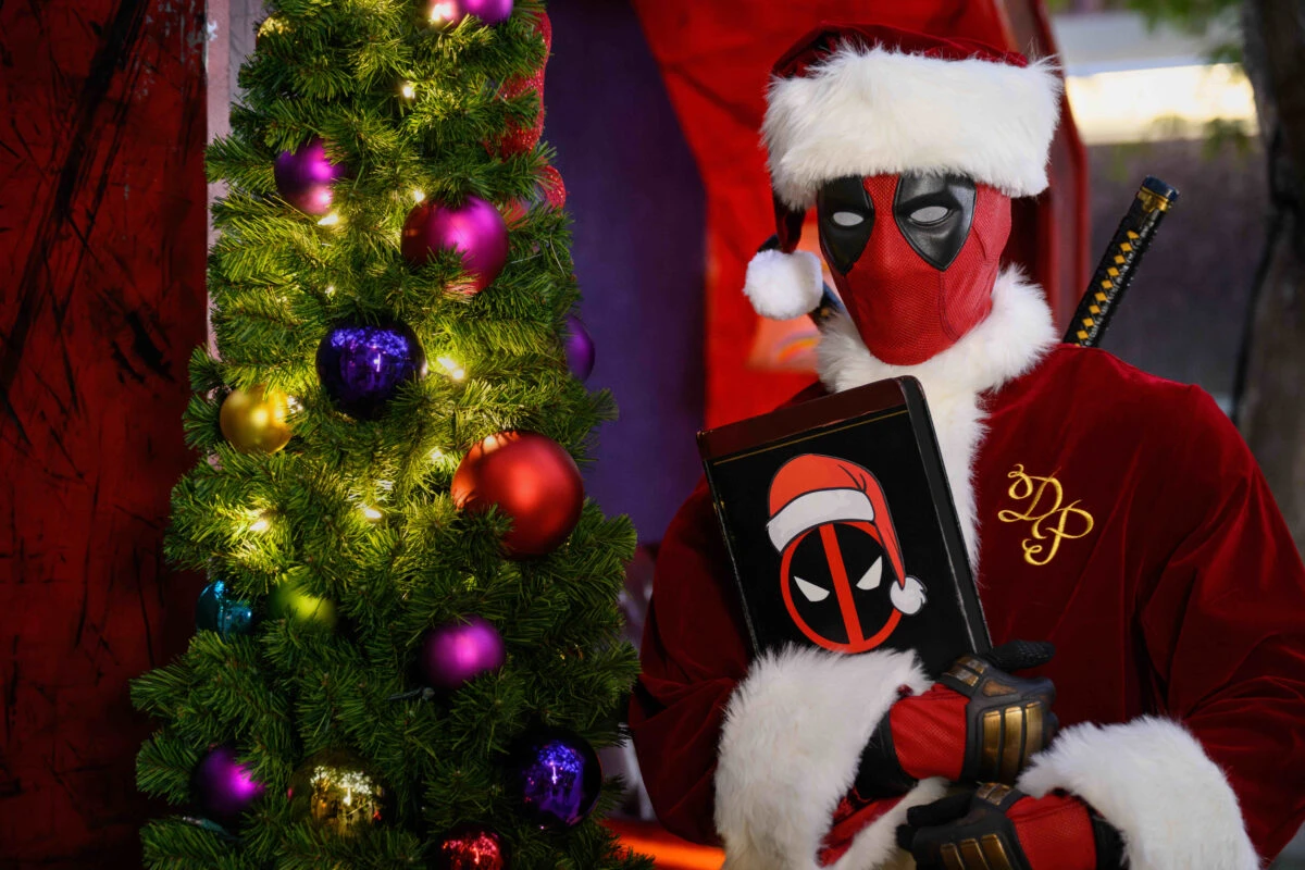 deadpool as santapool beside a Christmas tree