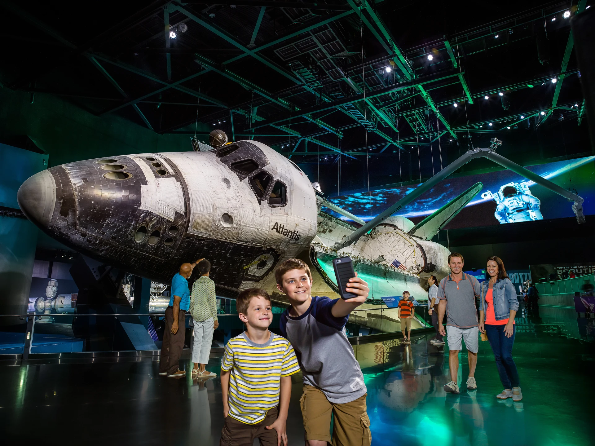 Two boys take a selfie in front of Atlantis at Kennedy Space Center.