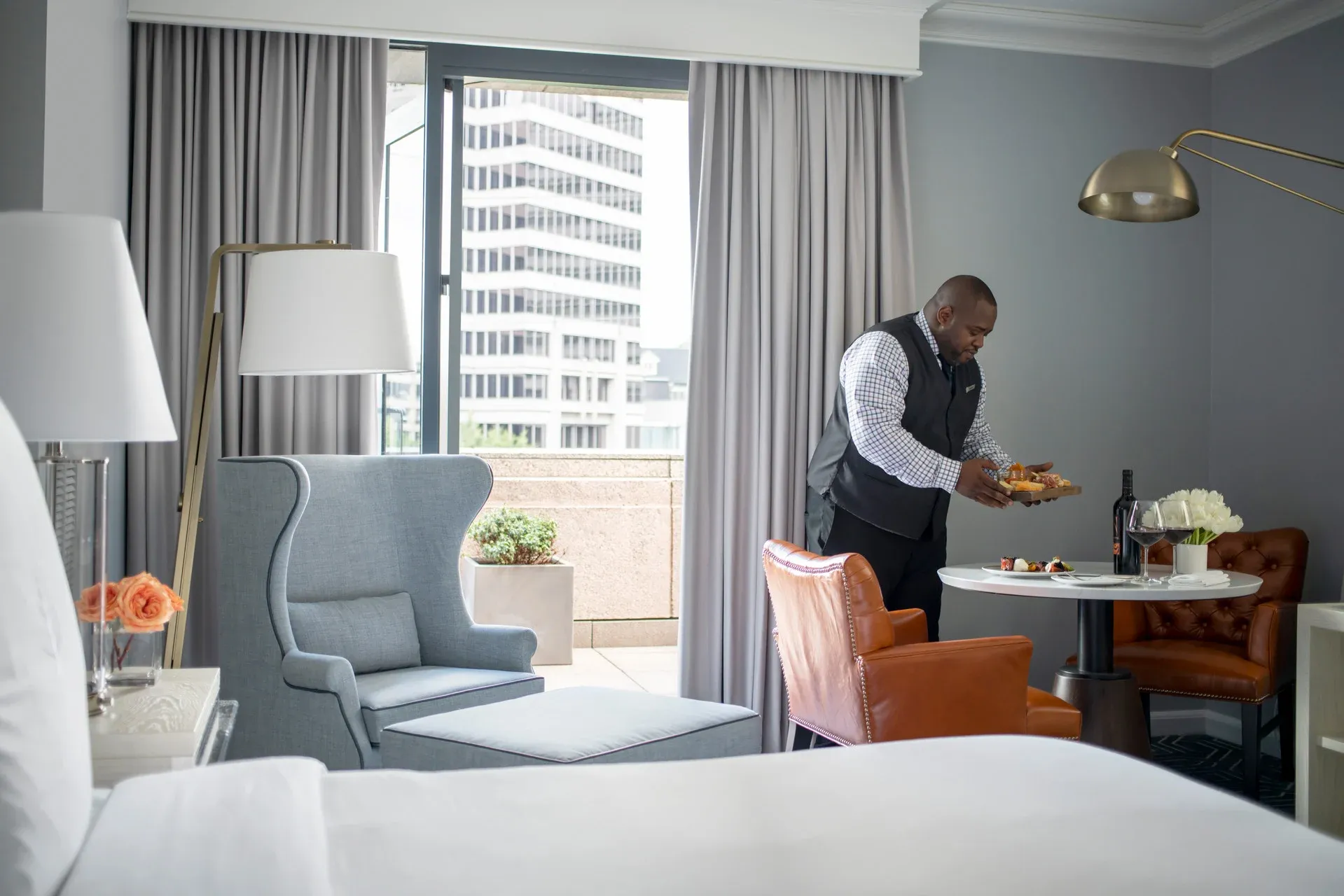 An attendant places a room service order on a table at Four Seasons Atlanta.