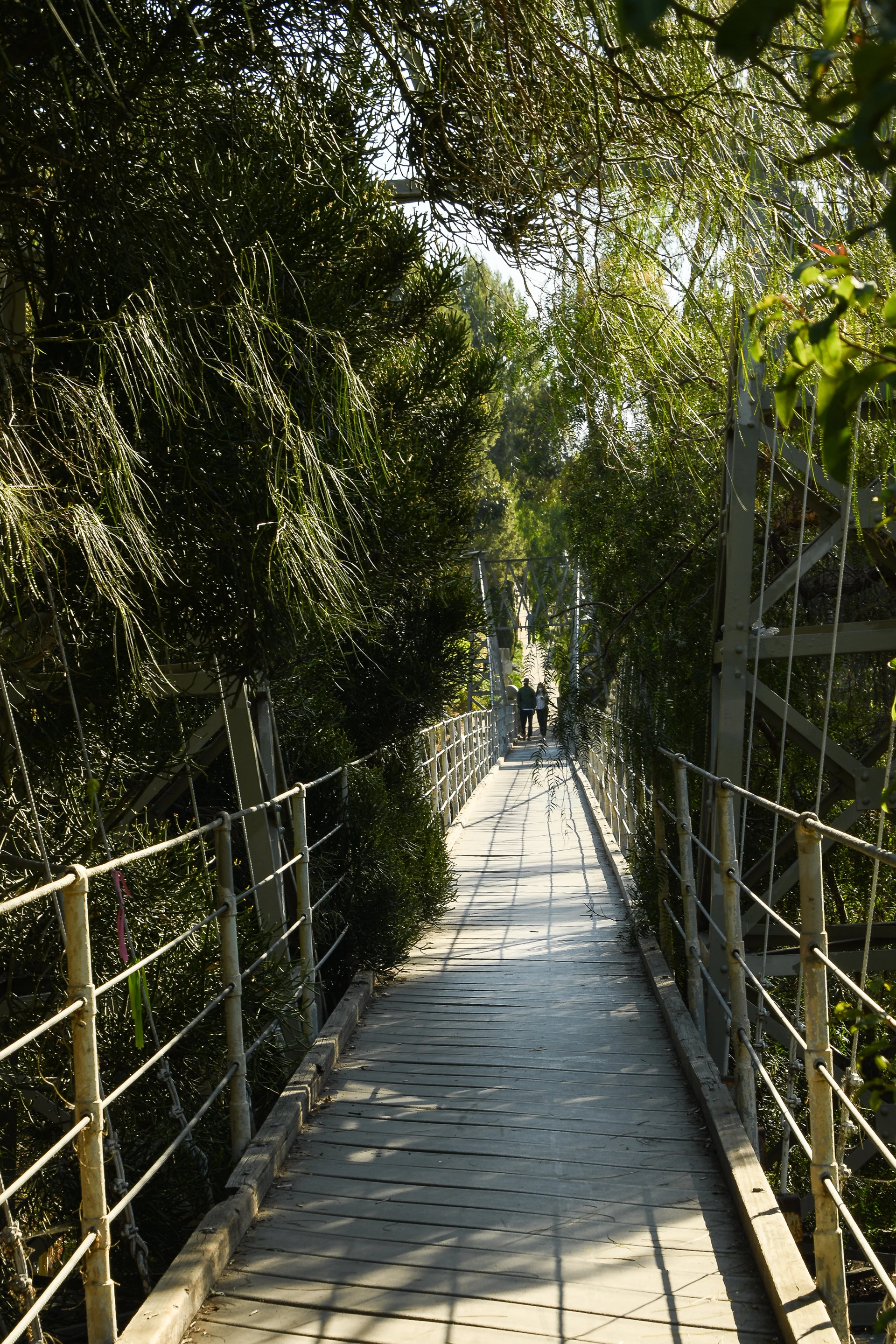 A couple walks over the Spruce Street Suspension Bridge a hidden gem in San Diego.
