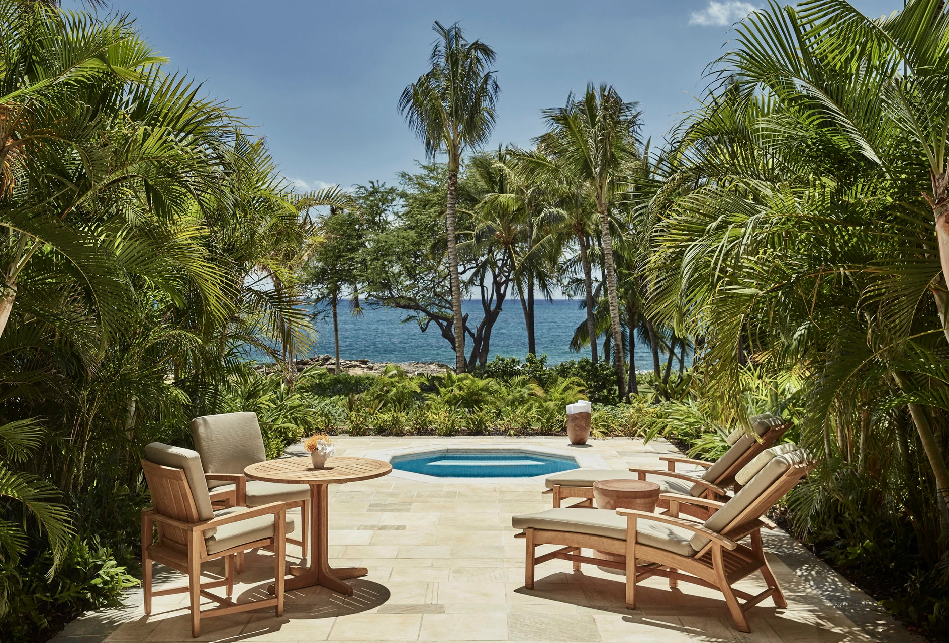 A hot tub on the Deluxe Room patio surrounded by palm trees.