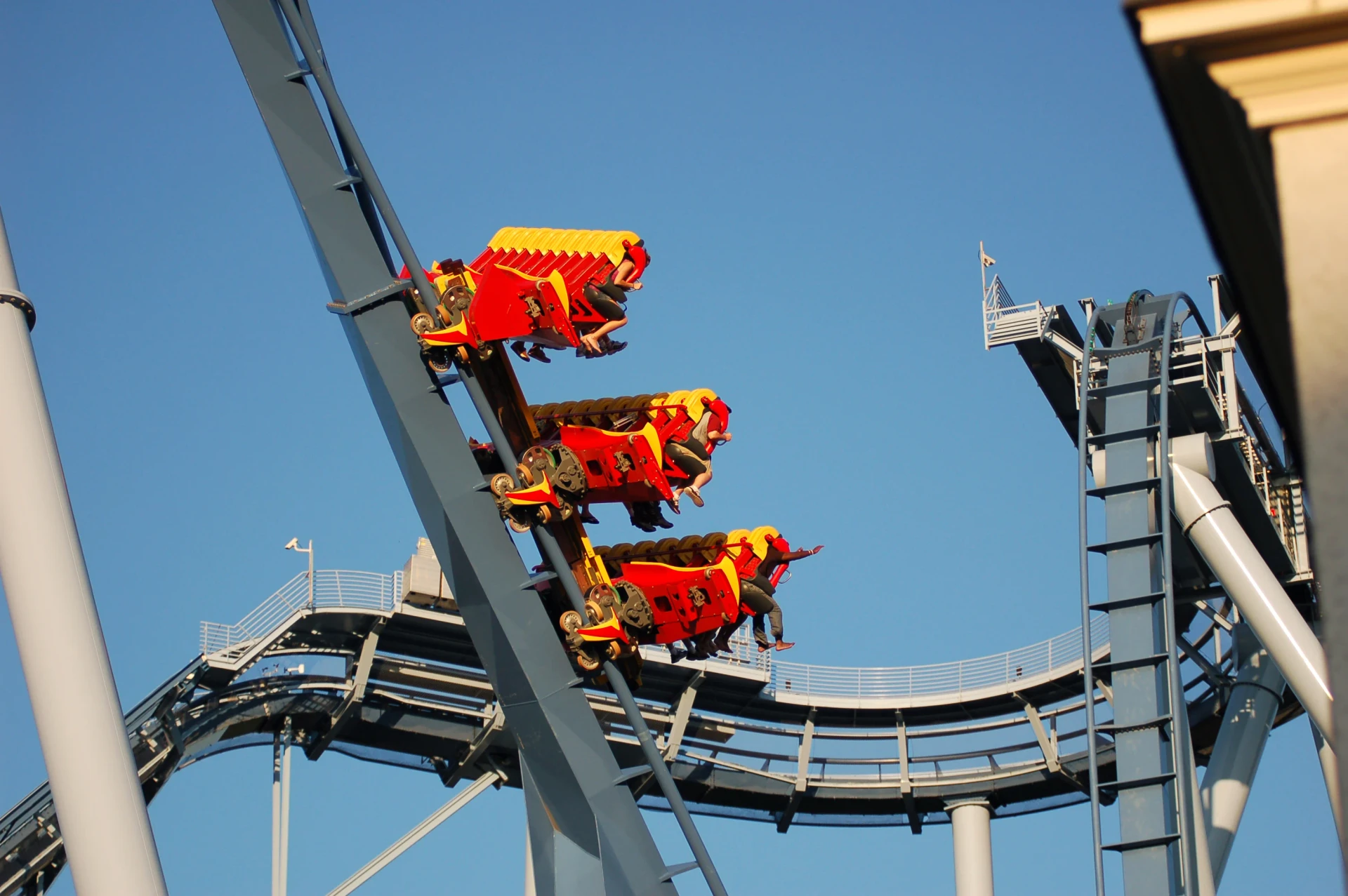 A red and yellow roller coaster car hurls down the track.