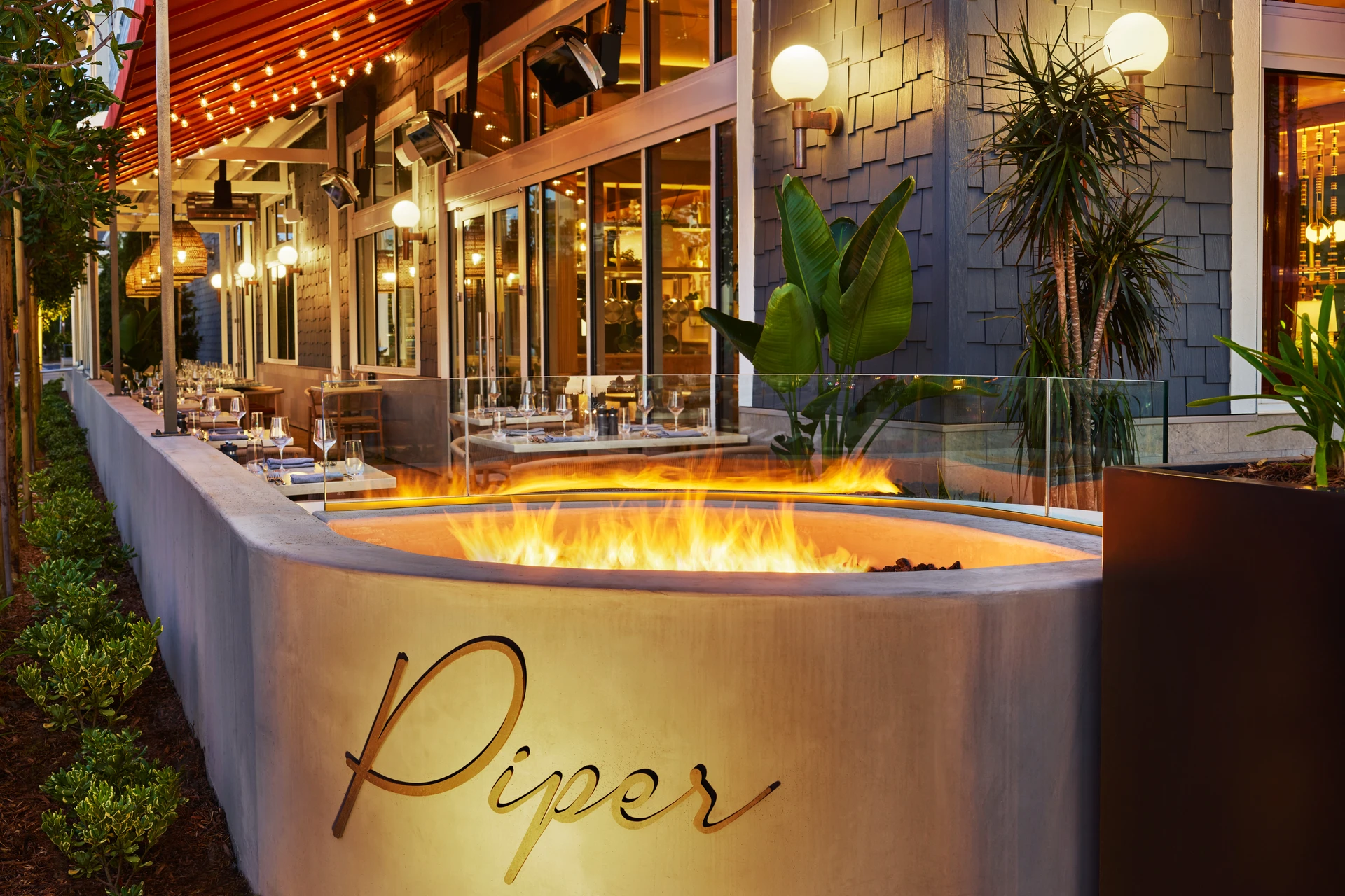 Piper restaurant terrace at night with fire pit.