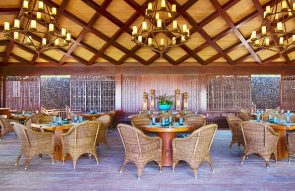 Wicker chairs and wooden tables set up at Beach Tree restaurant.