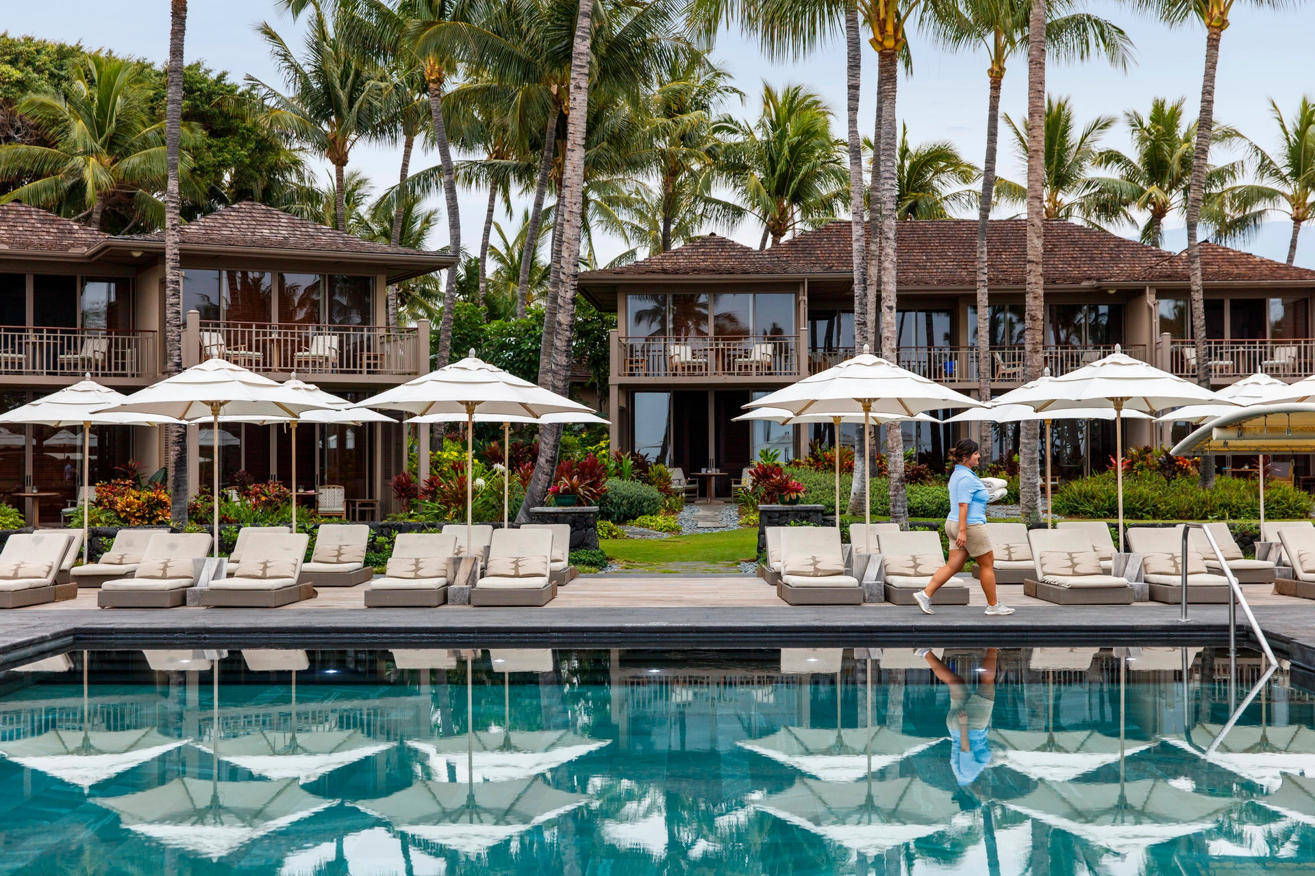 A pool attendant walks by the Palm Grove Pool at Four Seasons Hualalai.