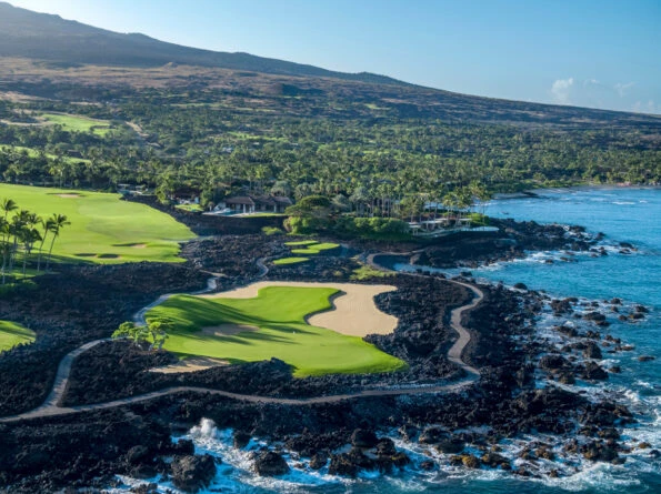 An oceanfront hole surrounded by lava rock at Hualalai Golf Course.