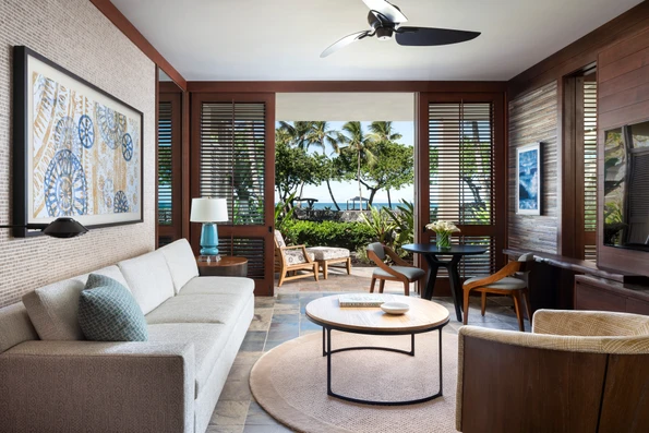 Superior Suite Ocean View living room with a view over foliage to the ocean.