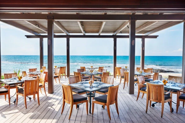 Tables on an oceanfront outdoor deck at ULU restaurant.