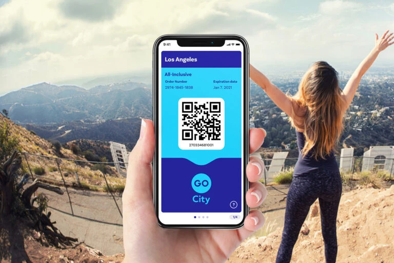 A person holds a mobile phone showing a Go City Los Angeles pass on the app.