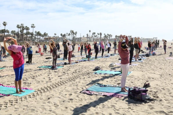 A group does yoga on the beach in Huntington Beach.