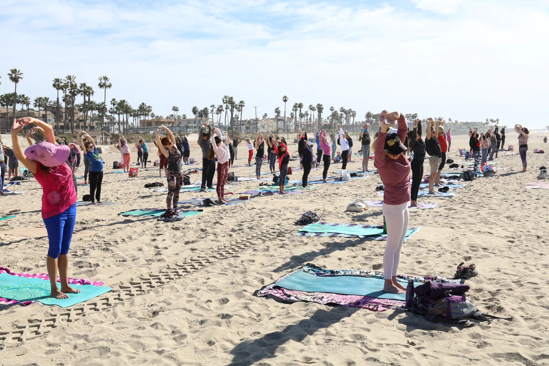 A group does yoga on the beach in Huntington Beach.