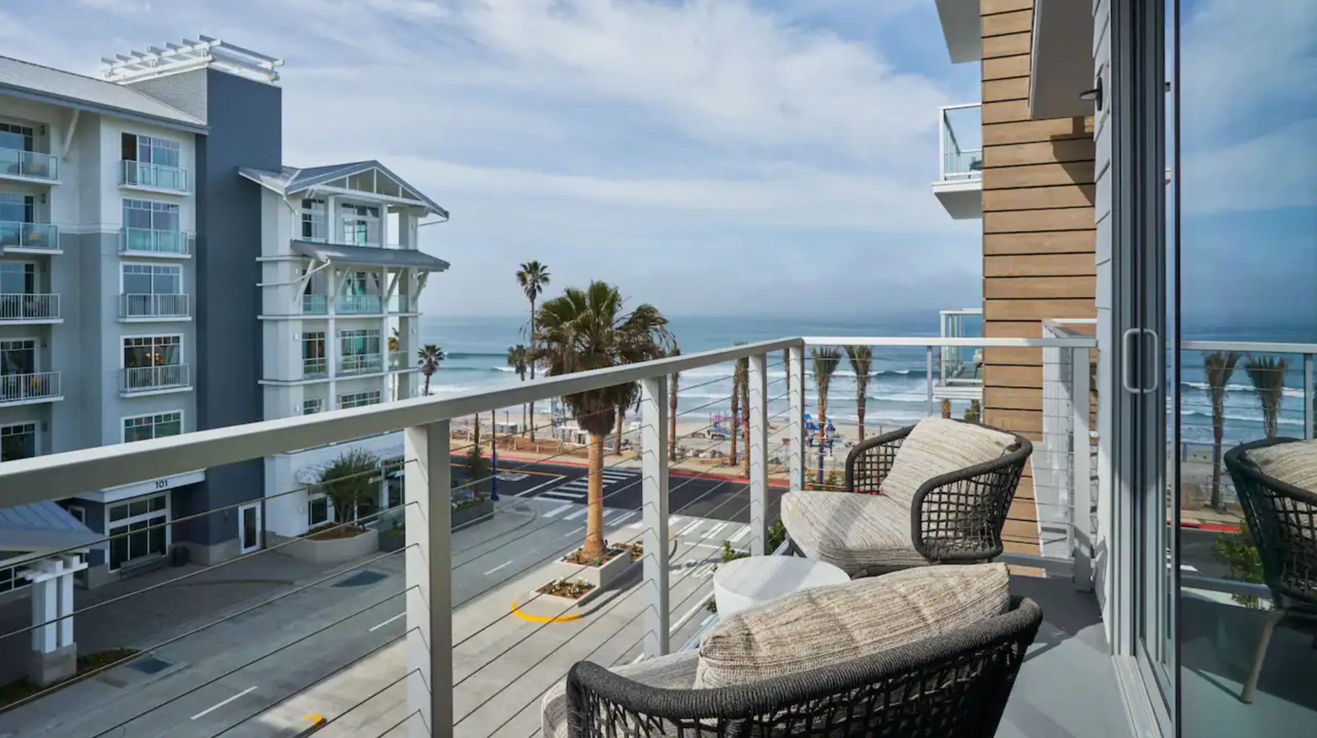 Balcony with two chairs facing The Seabird Resort and the ocean.