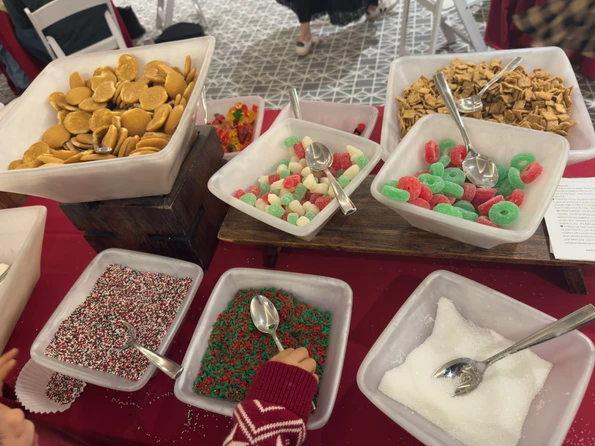 Bowls of candy and decorations on the table for kids to grab for gingerbread houses.