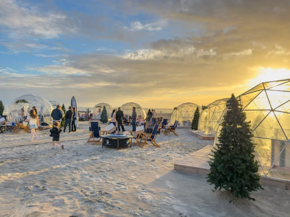 Families enjoy the igloos at sunset.