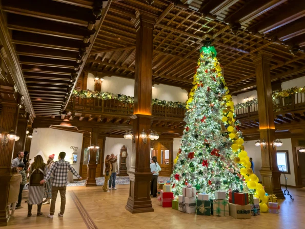 Guests take photos in front of the Yellow Brick road Christmas Tree in the Victorian lobby.