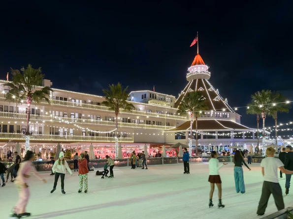 People ice skate at Hotel del Coronado at night.