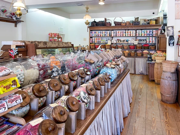 Candy jars lined up inside on a table at Cousins Candy shop.