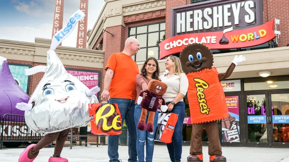 A family stands with Hershey candy characters.