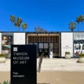 Exterior of Timken Museum of Art in San Diego with blue sky and palm trees in the background.