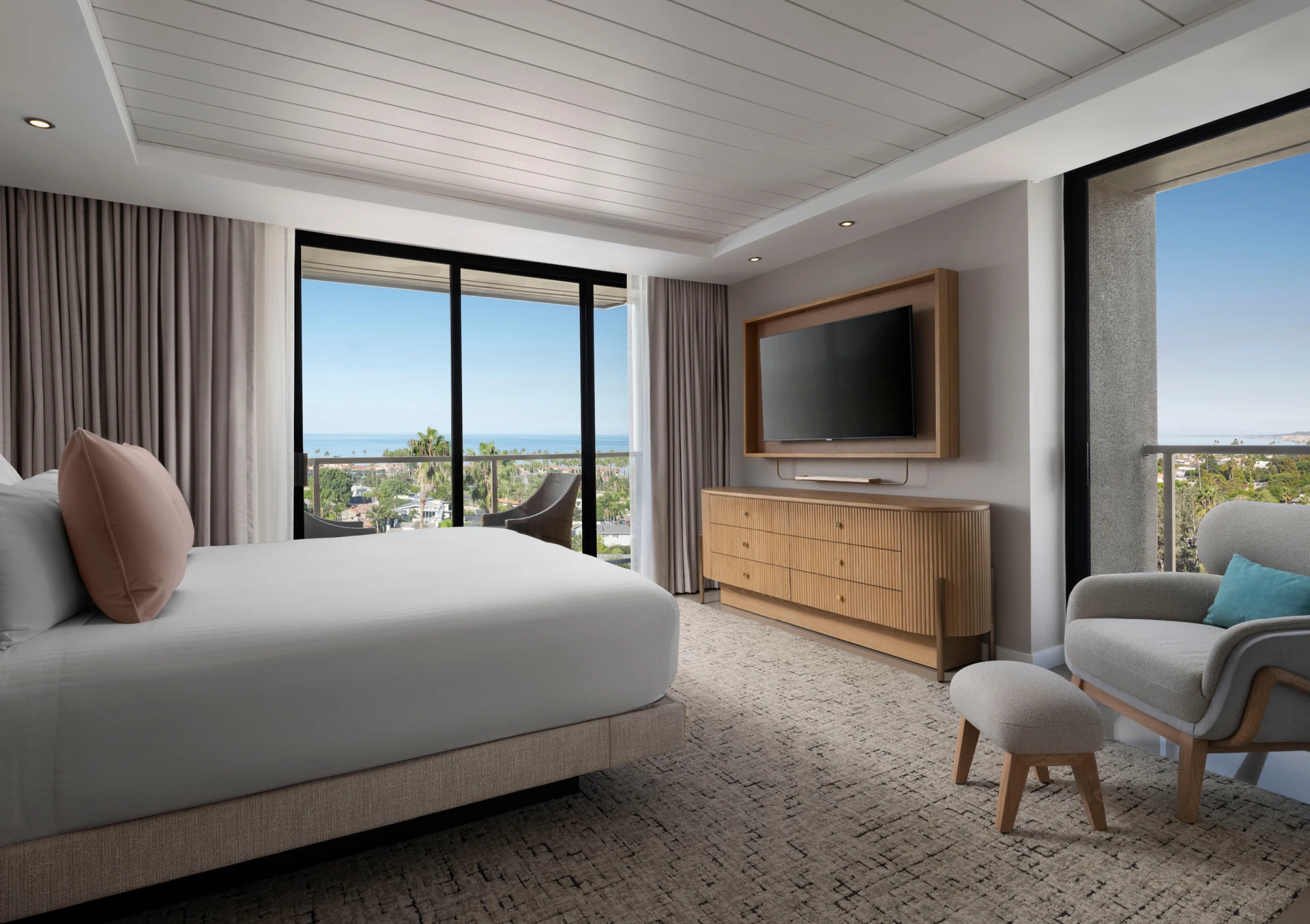 A corner suite bedroom with views through windows on both walls.