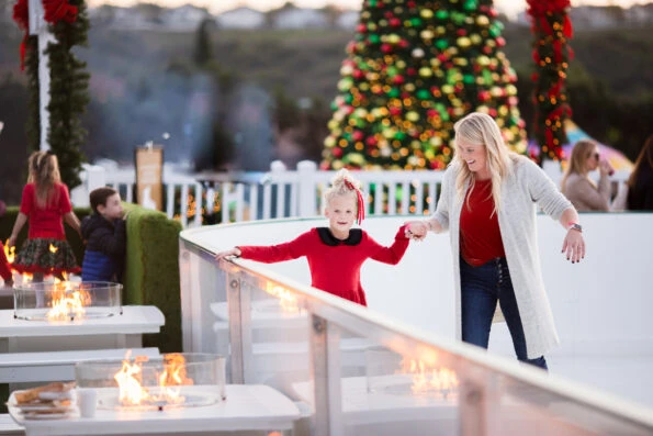 A woman and young daughter glice skate at Fairmont Grand Del Mar winter wonderland
