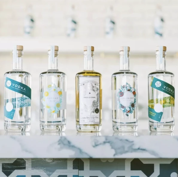Vodka bottles in various flavors lined up on a marble countertop.