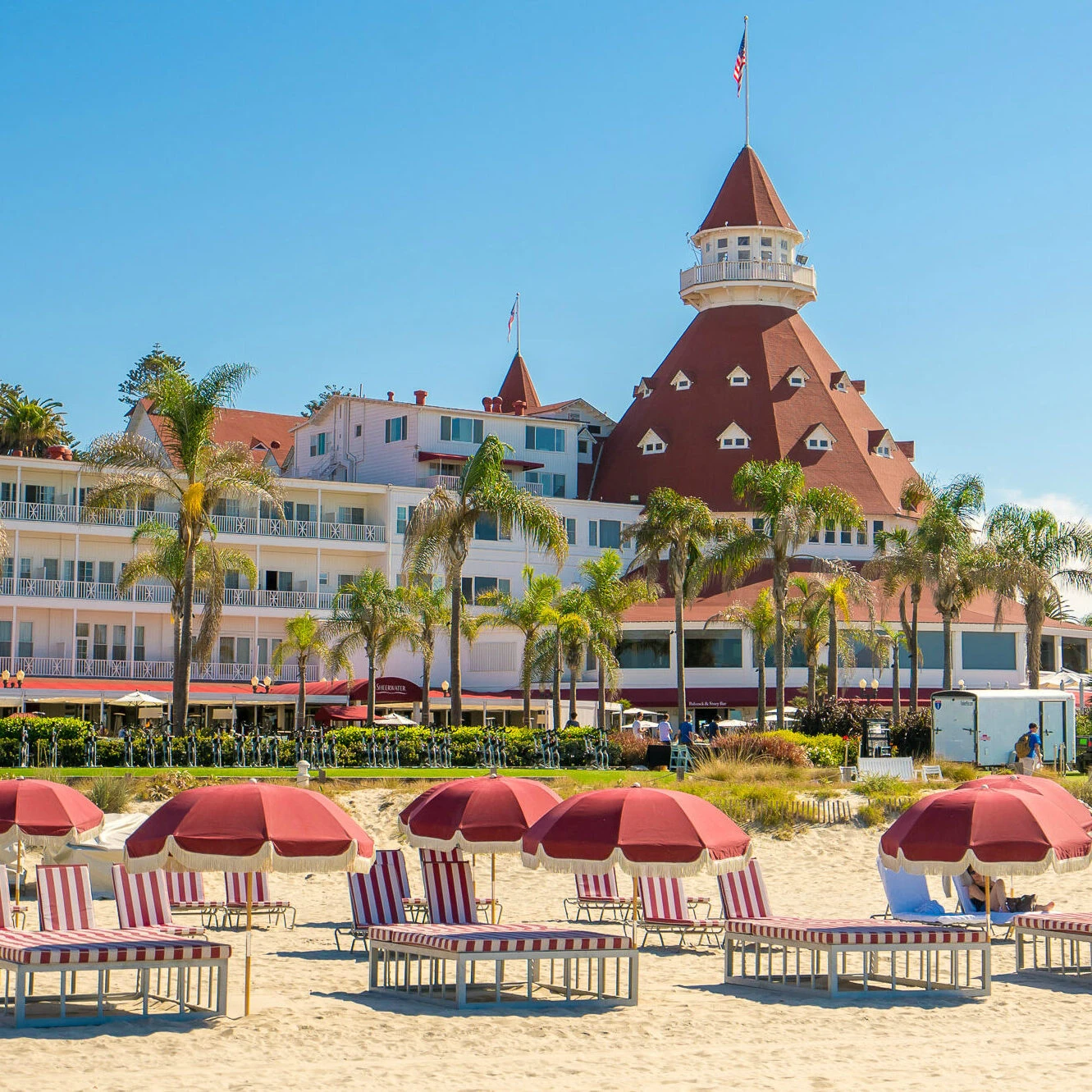 Red and white striped lounge chairs on the beach in front of Hotel Del Coronado.