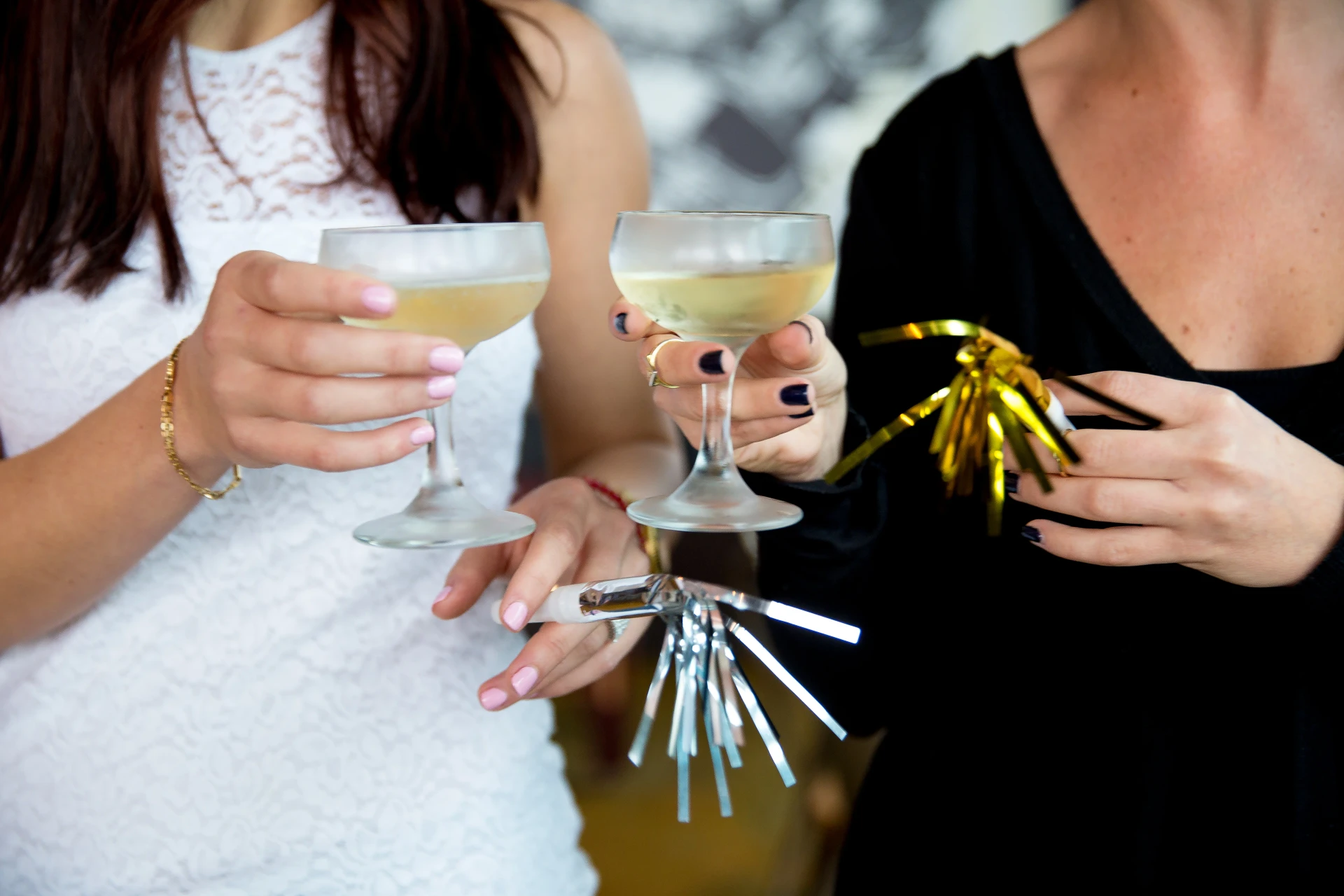 Two women toast with champagne flutes at JRDN in San Diego