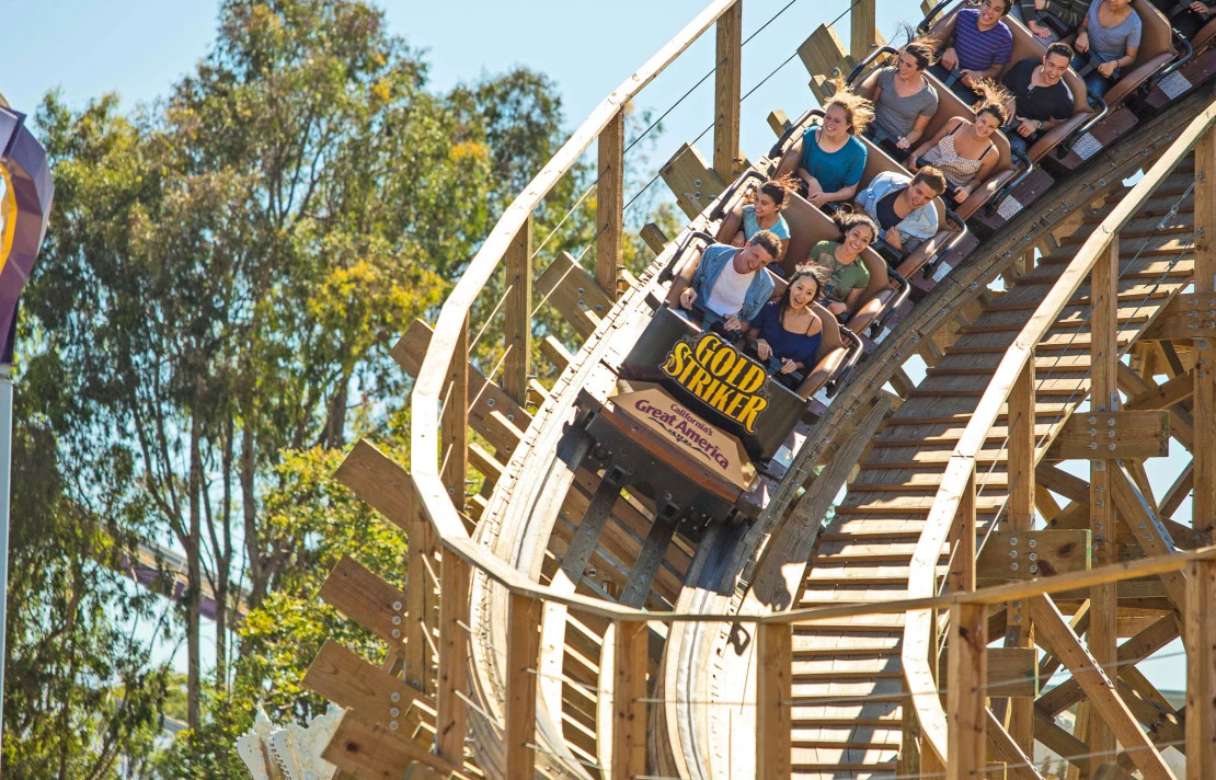 The Gold Striker roller coaster flies down the wooden track.