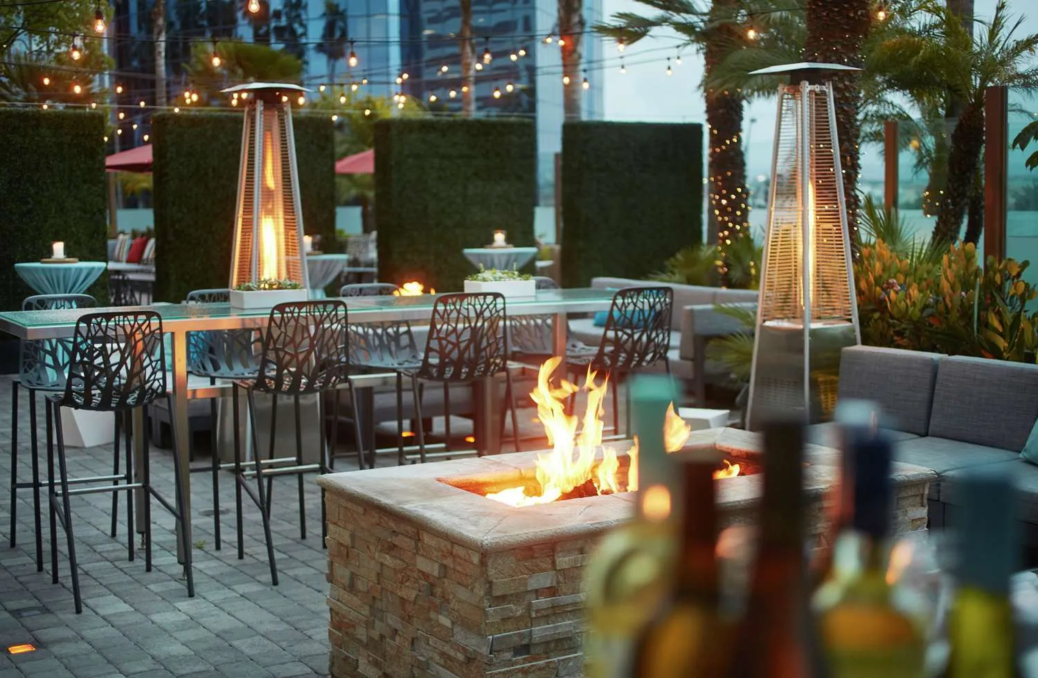 A cosy and well decorated outdoor lounge with heaters and fire pits.