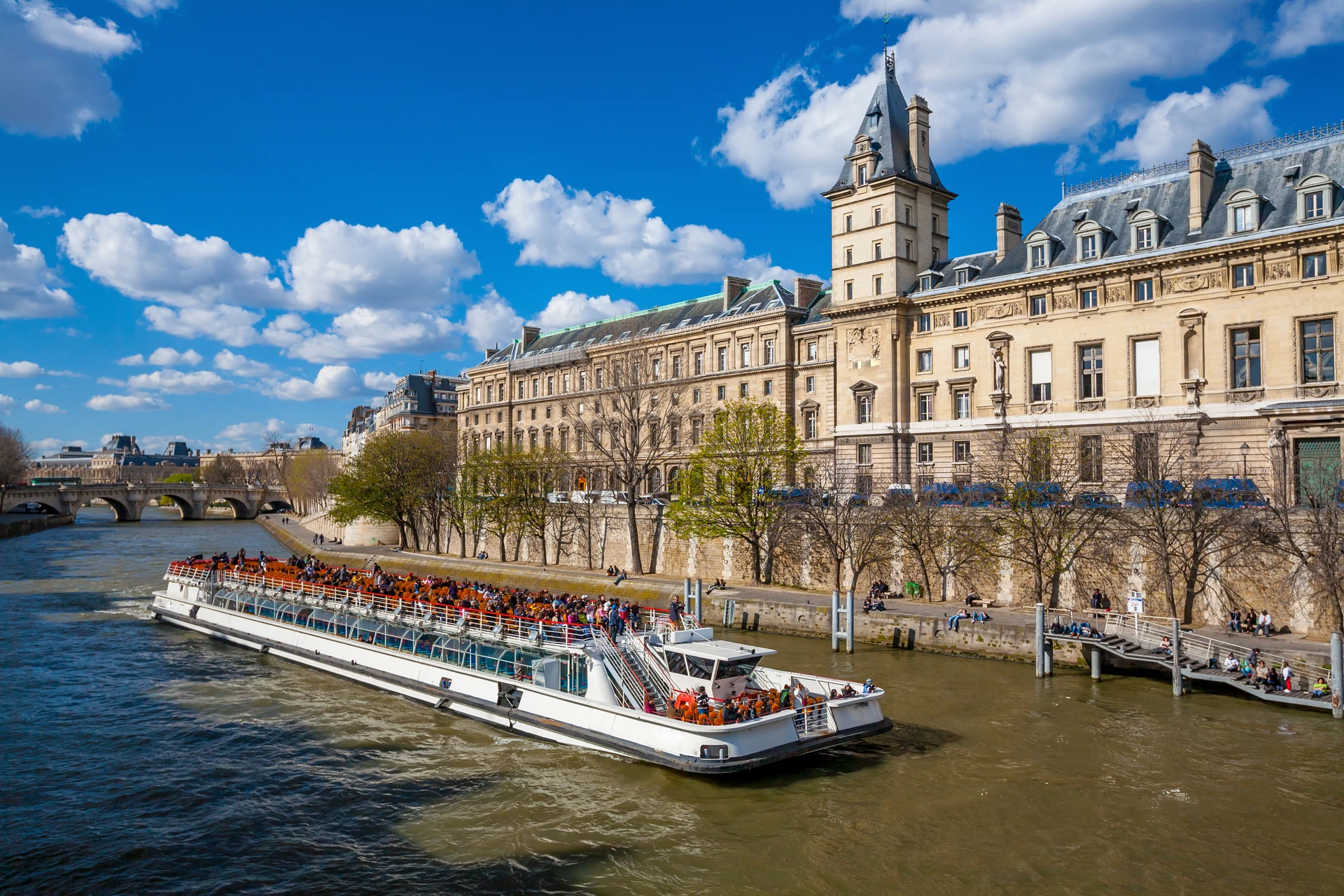 A Seine cruise with passengers sailing on a sunny day.