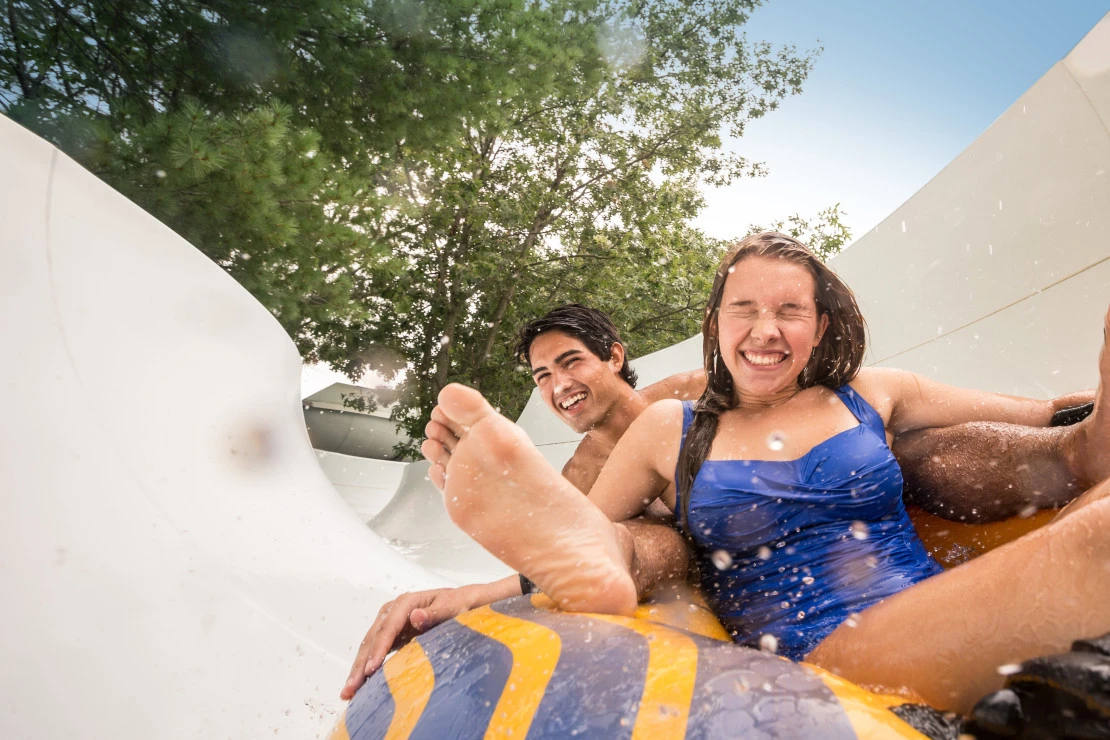 A boy and girl slide in a tube down a water slide at Noah's Ark Waterpark.