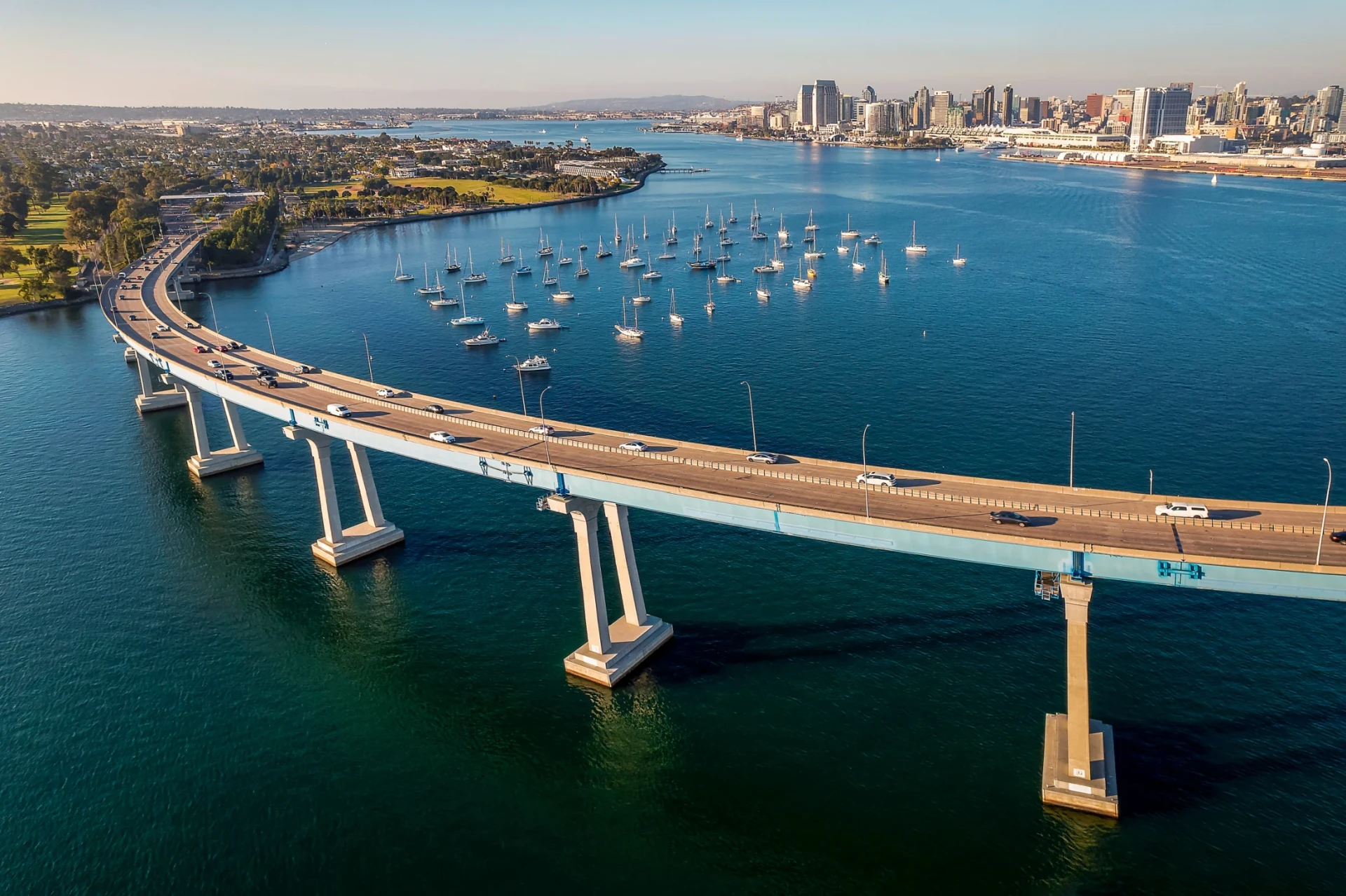 Cars drive over Coronado Bridge on a sunny day.