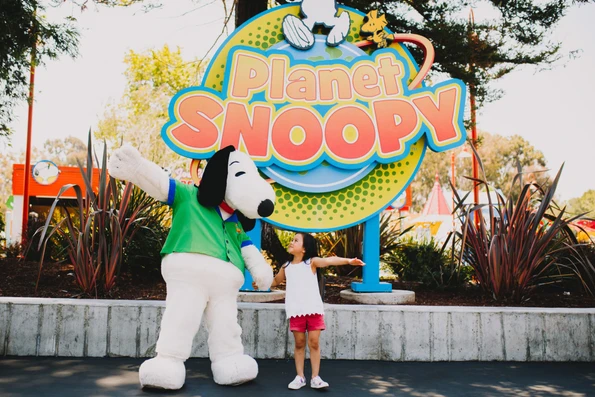A little girl stands with Snoopy at California's Great America.