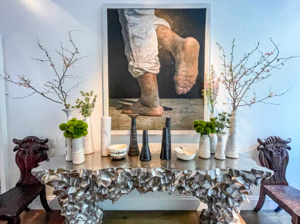 Painting with eclectic furniture and vases full of plants and branches that all look great together.