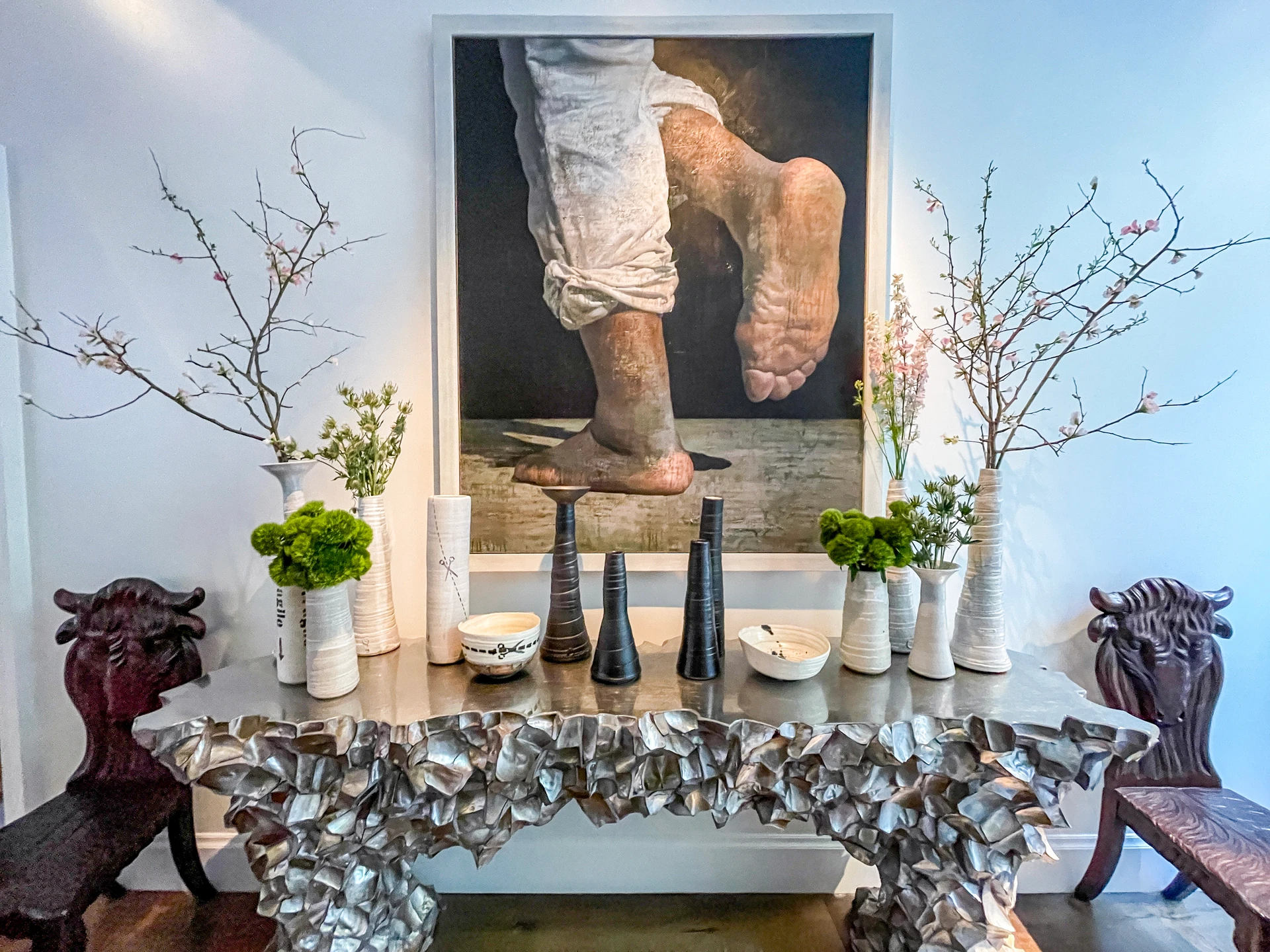 Painting with eclectic furniture and vases full of plants and branches that all look great together.