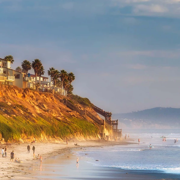 People walk along South Carlsbad State Beach, a fun Carlsbad activity,