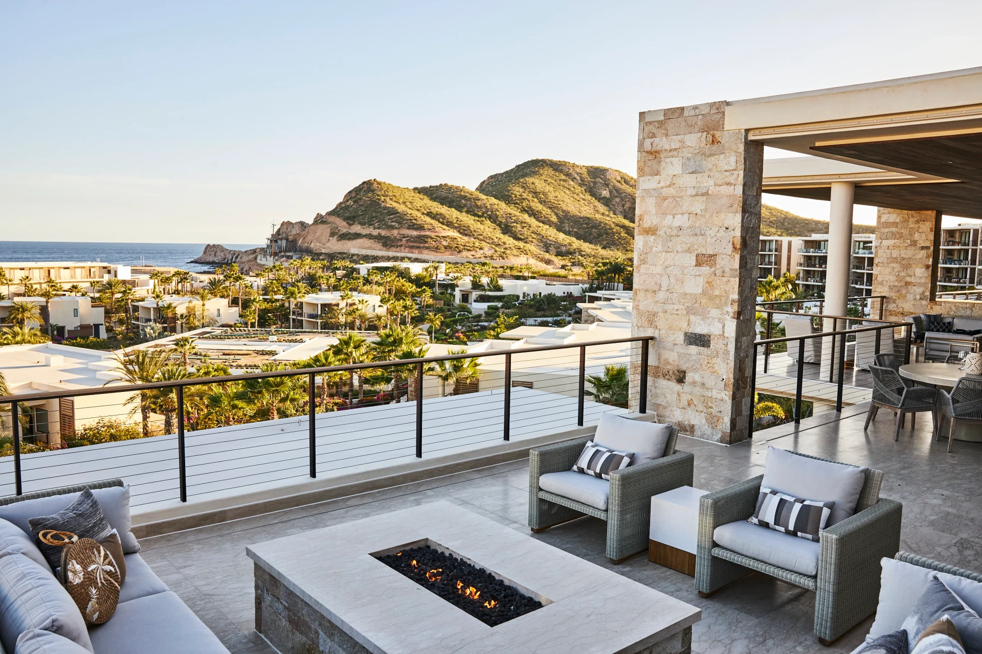 View from an outdoor seating area and fire pit out over the resort buildings to the ocean.