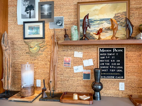 A cool lobby area with water for guests and a board showing the tide conditions in front of the hotel.