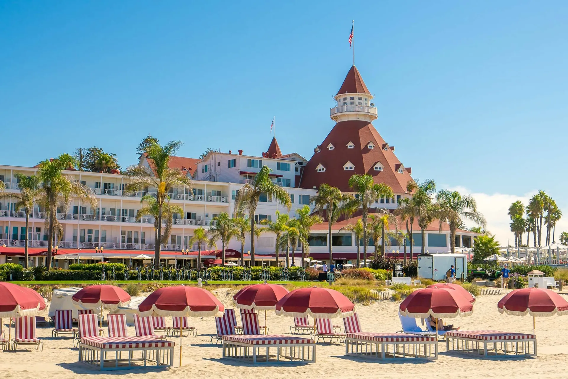 Red and white striped lounge chairs on the beach in front of Hotel Del Coronado.