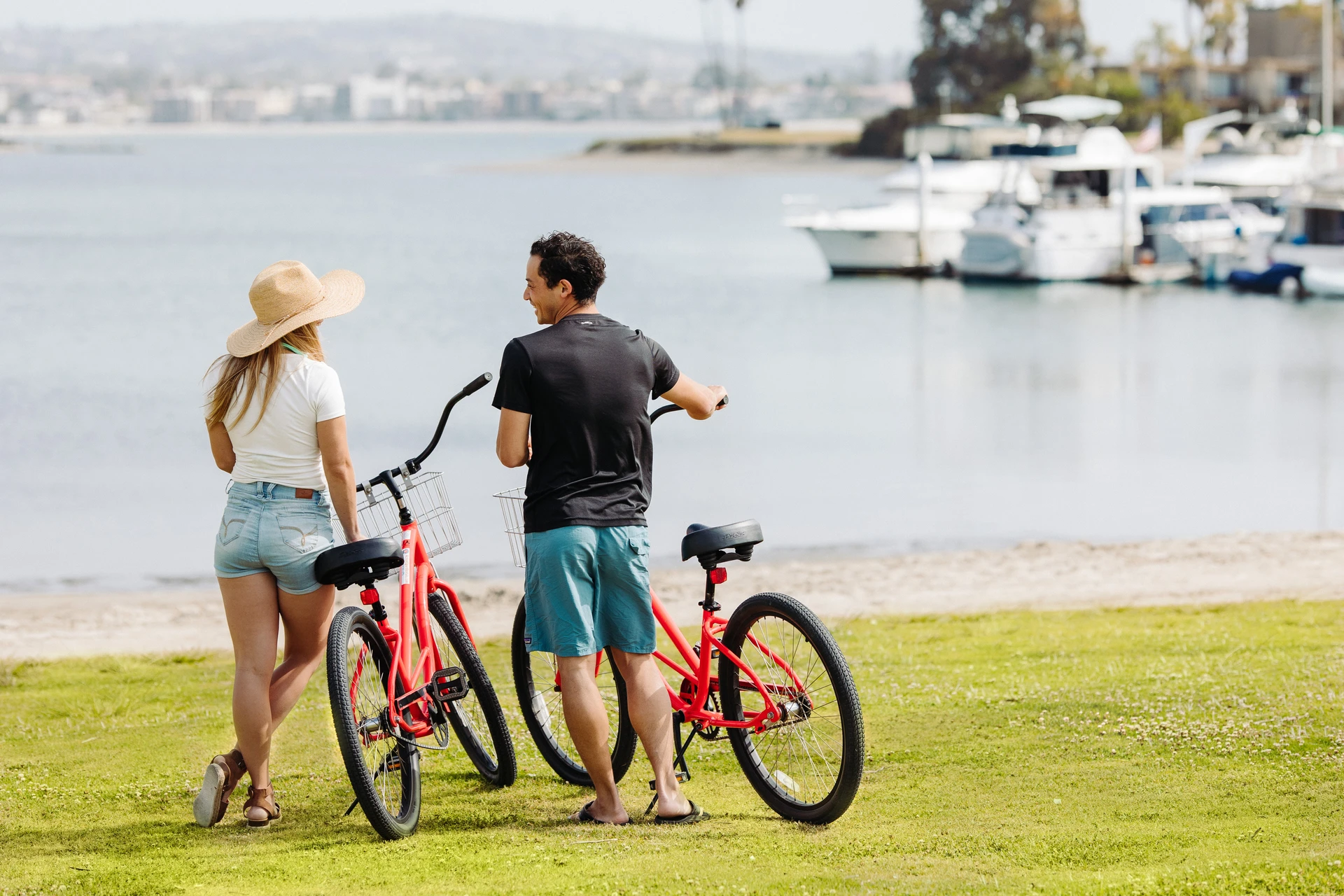 Woman and man standing beside their bikes at the beach