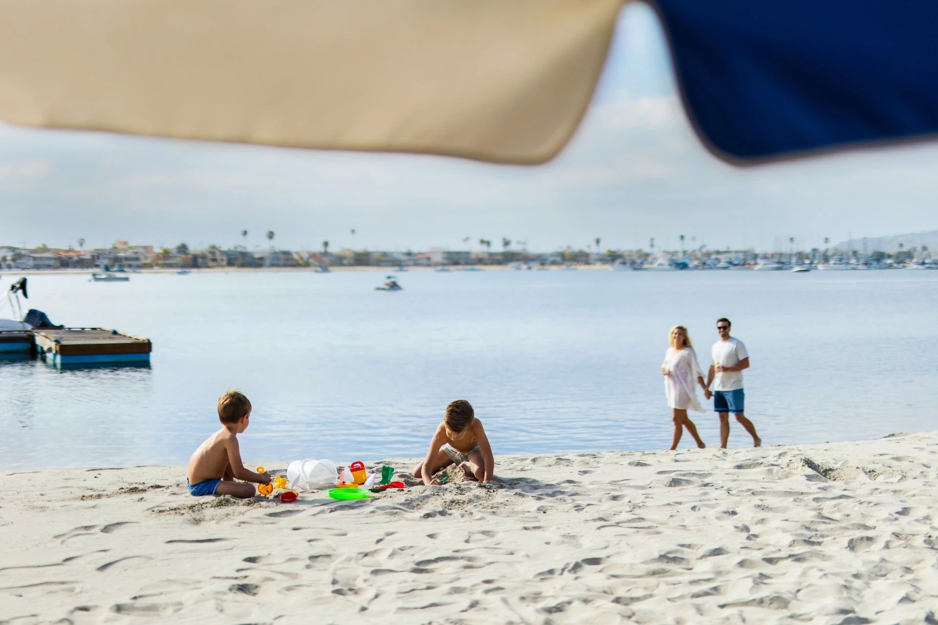 Kids playing sand at the beach in front of Bahia Resort Hotel.