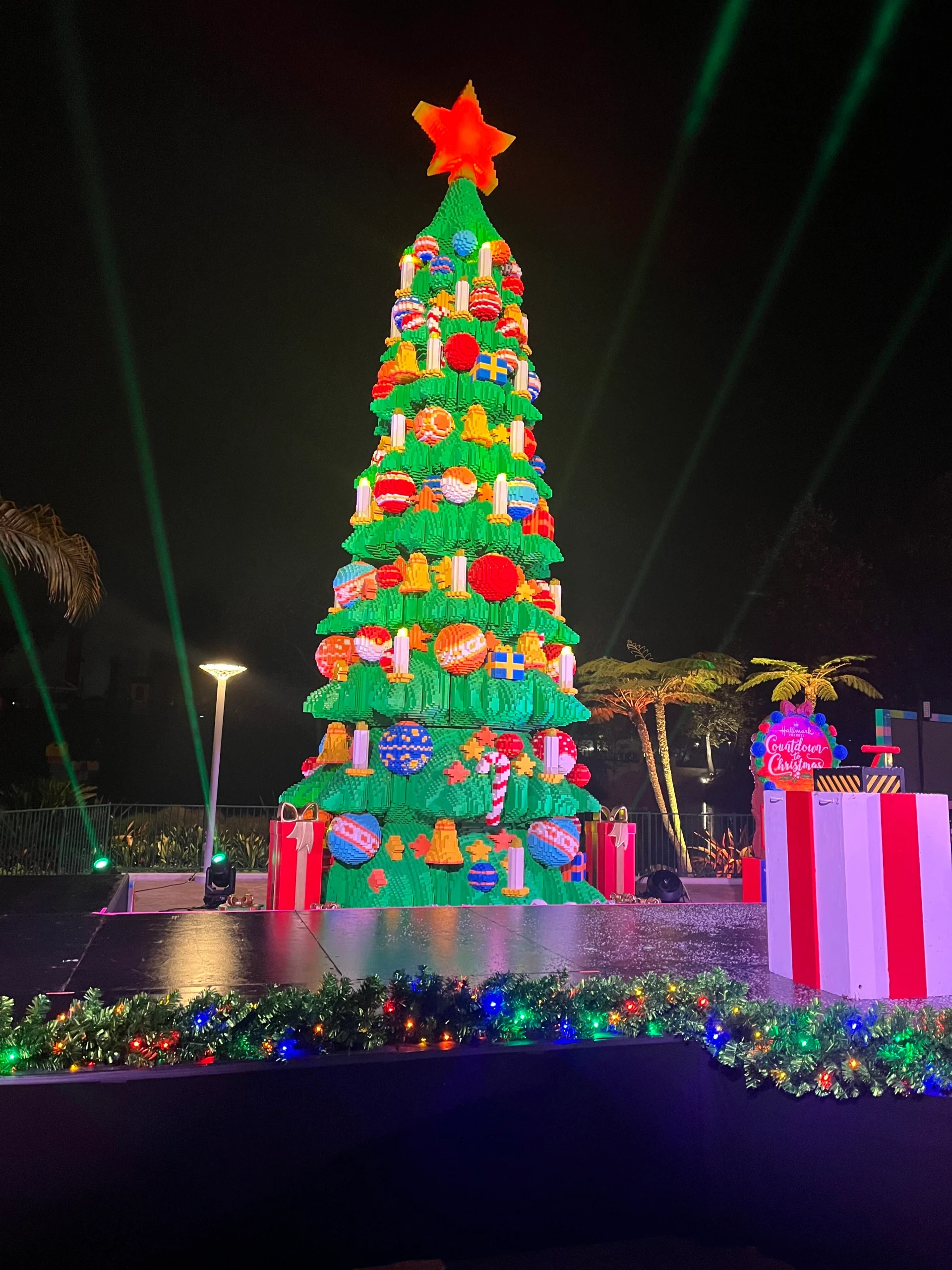 The LEGO Christmas tree lit up at night.