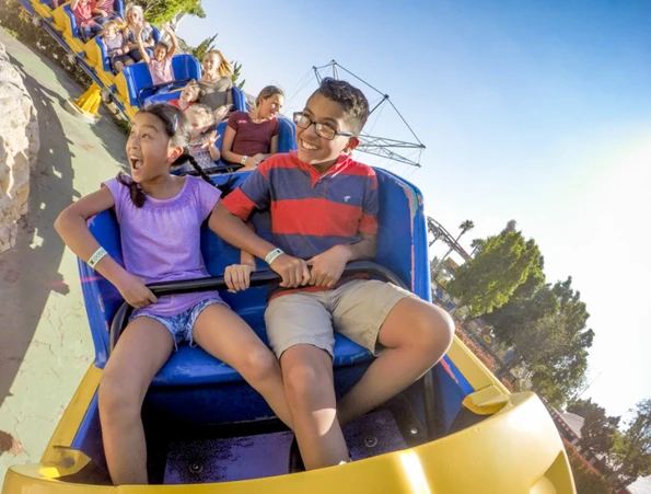kids riding roller coaster in castle park