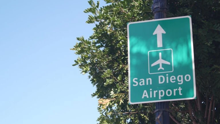 A street sign that points to San Diego Airport.