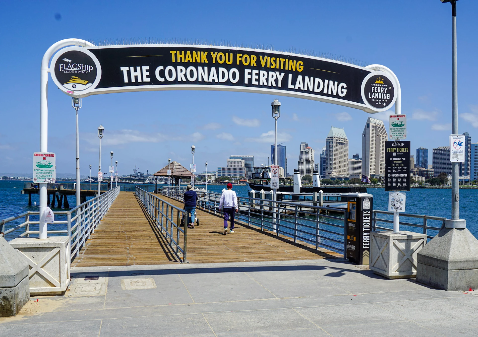 A family walks on the pier toward the Coronado Ferry.