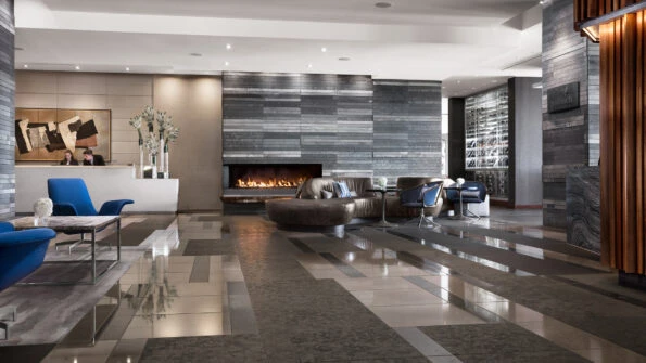 Two front desk staff members work in the lobby