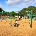 Katie's daughter swings on a plays structure at Kate Sessions Park in San Diego.